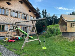 einen Spielplatz in einem Hof neben einem Haus in der Unterkunft Ferienwohnung Schönenbühl in Hittisau