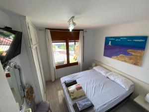 Dormitorio pequeño con cama y TV en TOSSA DE MAR, MIRAMAR con piscina, en Tossa de Mar
