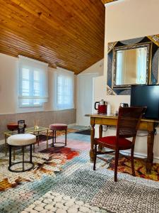 a living room with a table and chairs and a wooden ceiling at Hotel De La Poste in Langres