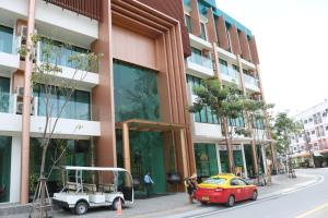 カマラビーチにあるOceana Resort Kamala Ocean View 5th floorの建物の前に駐車された車とゴルフカート