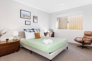 een slaapkamer met een bed en een stoel bij Barry's Holiday Home Dunsborough in Dunsborough