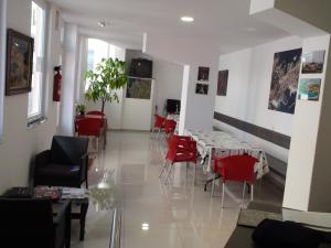 a dining room with red chairs and tables at Albergue @ Muxia in Muxia