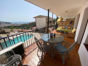 balcón con mesa, sillas y piscina en TOSSA DE MAR, MIRAMAR con piscina, en Tossa de Mar