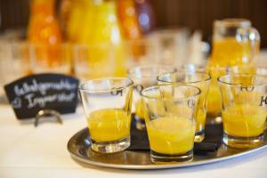 ein Tablett mit mehreren Gläsern Orangensaft auf einem Tisch in der Unterkunft ElzLand Hotel Pfauen WELLNESS & SPA in Elzach