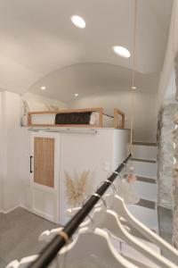 un trípode en una habitación con escalera y escalera en "Voras Luxury Cave Loft", en Naxos Chora