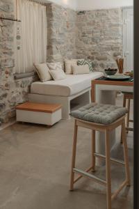 sala de estar con sofá y taburete en "Voras Luxury Cave Loft", en Naxos Chora