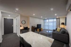 a living room with a couch and a table at Avenue Hotel Canberra in Canberra