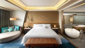 a bedroom with a bed and a bath tub and a bed and a sink at The Westin Sanya Haitang Bay Resort in Sanya