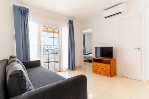 a living room with a couch and a television at Las Casitas de Corralejo in Corralejo