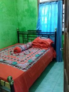 Kepulauan SeribuにあるLosmen Lima Saudaraのベッドルーム1室(赤いシーツと青いカーテンのベッド1台付)