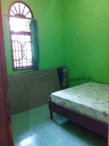 Tempat tidur dalam kamar di Losmen Lima Saudara