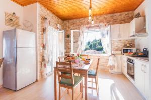 a kitchen with a table and a refrigerator at Corfu sight Blue in Spartýlas