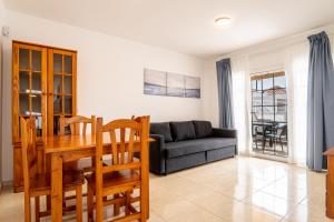 een woonkamer met een tafel en een bank bij Las Casitas de Corralejo in Corralejo