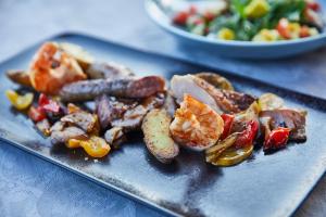 un piatto di alimenti con salsiccia e verdure su un tavolo di ElzLand Hotel Pfauen WELLNESS & SPA a Elzach