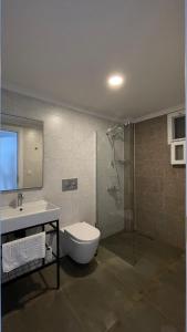 a bathroom with a shower and a toilet and a sink at Gülhan City Otel in Datca