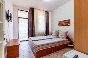 Kleines Zimmer mit einem Bett und einem Fenster in der Unterkunft Vila Emily in Buşteni