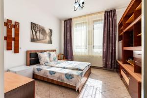 ein kleines Schlafzimmer mit einem Bett und einem Fenster in der Unterkunft Vila Emily in Buşteni