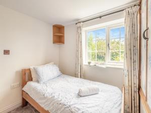 a small bedroom with a bed and a window at Townhead Cottage in Newbiggin