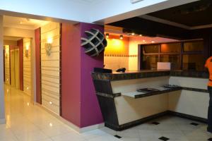 a kitchen with purple walls and a counter at Gloria Hotel in Kigali