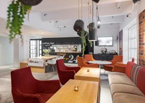 a restaurant with orange chairs and tables and a counter at Original Sokos Hotel Villa Tampere in Tampere