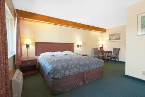 a hotel room with a large bed and a table at Broadway Inn by OYO Portland Downtown in Portland