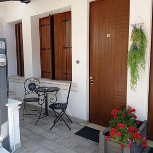 a porch with a table and chairs and a door at CQ Rooms Verona in Verona