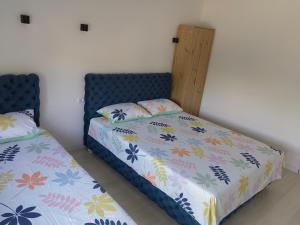 - une chambre avec 2 lits et une tête de lit bleue dans l'établissement APARTMANI JORGIĆ, à Pačir