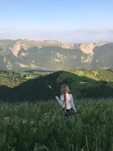 a girl is sitting in a field of grass at Le refuge du berger in Choux