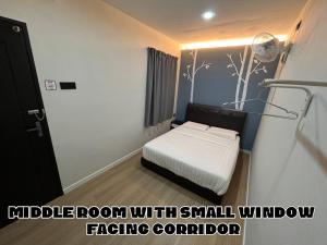 um pequeno quarto com uma cama e uma pequena janela em OU INN Cameron Highlands ,Ferm Nyonya Restaurant em Tanah Rata