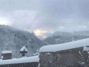 a stone wall with snow on top of a mountain at Le refuge du berger in Choux +4 photos