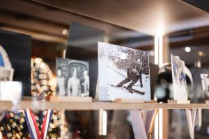 une étagère avec des photos d'un homme à skis dans l'établissement Hotel Ladinia, à La Villa