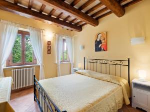 ein Schlafzimmer mit einem Bett und zwei Fenstern in der Unterkunft Beautiful Villa in Belforte all Isauro with Swimming Pool in Belforte allʼIsauro