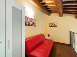 ein rotes Sofa im Wohnzimmer mit Holzdecken in der Unterkunft Beautiful Villa in Belforte all Isauro with Swimming Pool in Belforte allʼIsauro