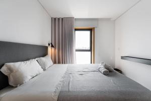 a bedroom with a large white bed with a window at GuestReady - A modern retreat in Porto in Porto