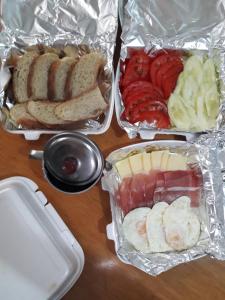 una mesa cubierta con bandejas de diferentes tipos de alimentos en Still cabin en Cetinje