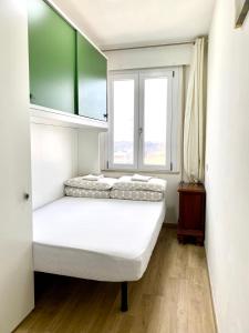 a bed in a room with two windows at Venice Mestre Station House in Mestre