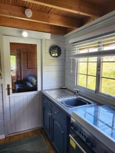 una pequeña cocina con fregadero y ventana en The Meadow en Lapworth