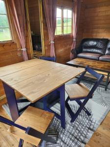 Lapworth的住宿－The Meadow，一张木桌和椅子,位于一个配有沙发的房间