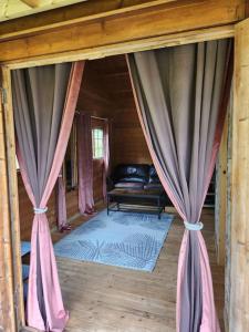 una habitación con sofá y cortinas en una cabaña en The Meadow en Lapworth