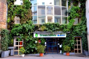 Un bâtiment avec un panneau d'industries vertes devant lui dans l'établissement Green hotels Confort Paris 13, à Paris
