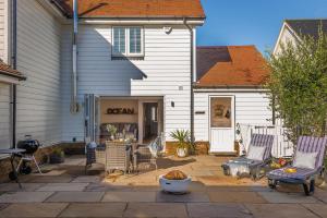 a patio with chairs and a table in front of a house at Ocean Beach in Camber