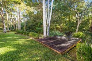 a wooden boardwalk in the middle of a yard at Tranquil Getaways On Obi Maleny in Maleny