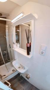 a white bathroom with a sink and a shower at Eagles Nest in Berlin