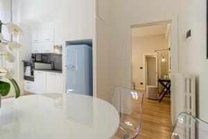 a white kitchen with a glass table and chairs at Casa Clio in Canton de Fiori in Bologna