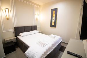 a hotel room with a bed with white sheets and towels at HOTEL GLAMOUR IMPERIAL in Buzău