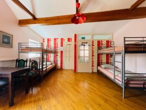 維爾紐斯的住宿－米卡洛旅舍，客房设有三张双层床和一张桌子。