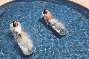 three people in a swimming pool in the water at Dreams Las Mareas All Inclusive in El Jobo