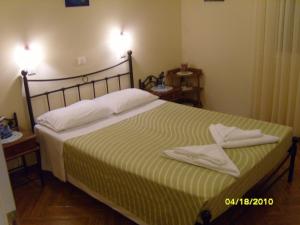 a bedroom with a bed with two towels on it at Elisabeth Villas in Kerveli