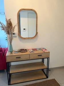 a dressing table with a mirror on a wall at Spacieux Appart T3+terrasse in Aix-les-Bains