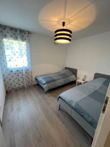 a bedroom with two beds and a light at Spacieux Appart T3+terrasse in Aix-les-Bains